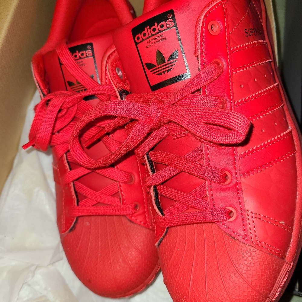 All red Adidas shell toes sneakers